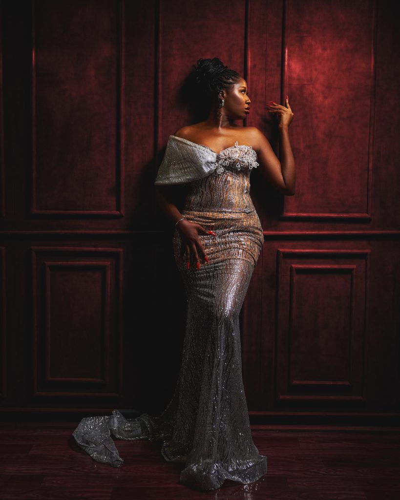 Portrait of a lady in a silver gown aganist a rustic wall